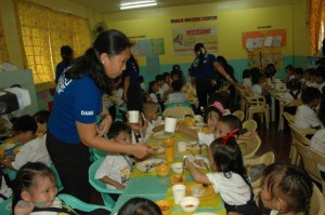 Day-care children enjoy the hot meals served by Day Care workers during a supplementary feeding activity.