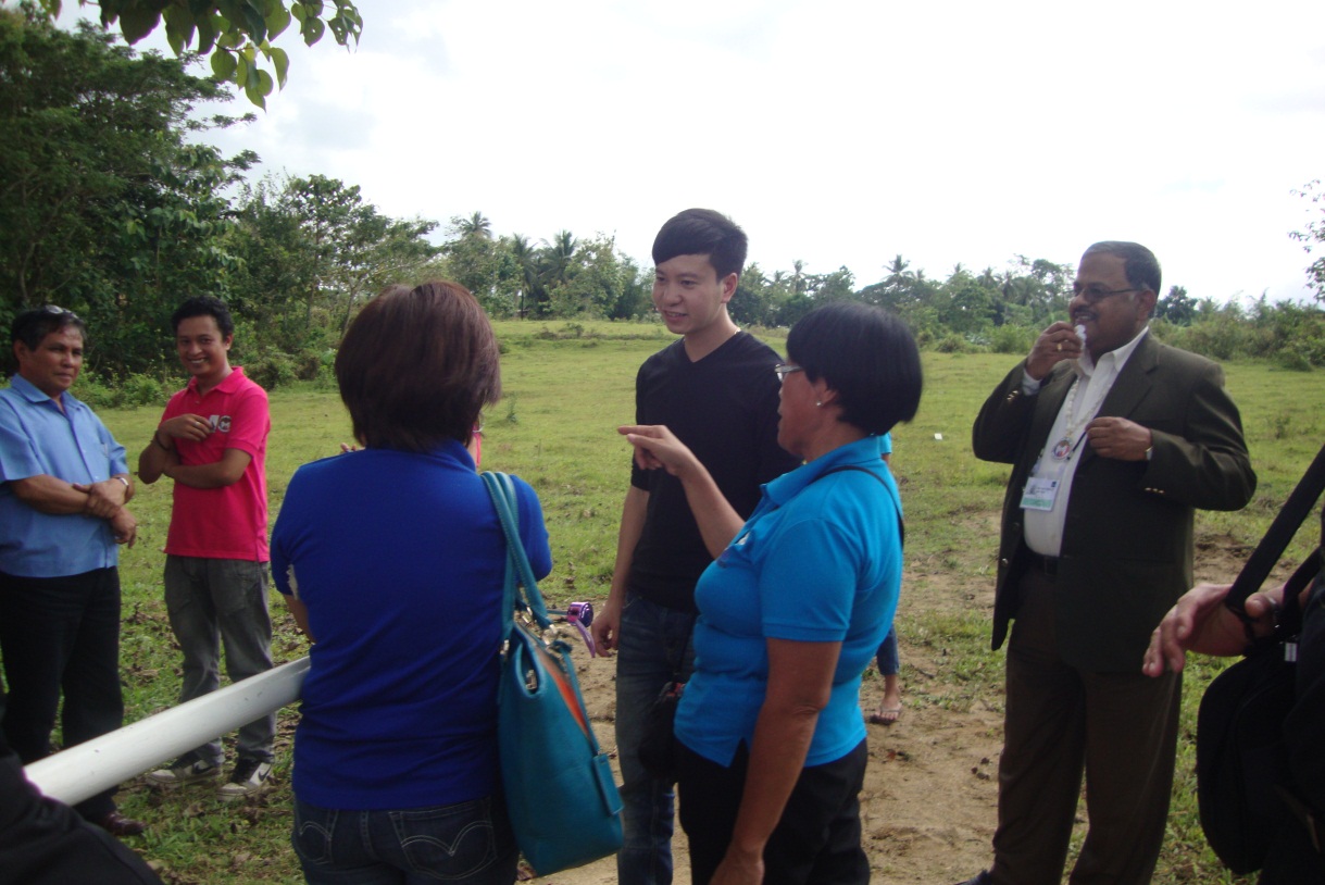 A community volunteer of Barangay Bayongan in Carmen, Bohol (center) and DSWD Assistant Regional Director Nemia Antipala (facing away from the camera) discuss the Kalahi-CIDSS footbridge subproject of the community with Vietnamese participant Mr. Dinh, Quang Thang as Bangladesh representative Mr. Shyama Prosad Adhikari looks on