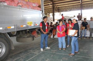 (Center) DSWD Sec. Dinky thanks USAID through their Area Team Leader Ainee Amboy (right) for the three truckloads of relief goods donated by USAID that were brought to the DPWH warehouse for repacking.