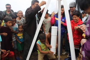 Two kids from Taluksangay assist Mayor Beng and Sec. Dinky during the placing of the time capsule during the groundbreaking ceremony.