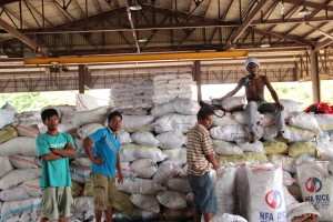 Men who are part of the DSWD's Cash-for-Work program pause for a break from hauling sacks of relief packs. Some of them are also evacuees of the armed conflict and flooding, joining the Cash-for-Work program to earn income while their families are in the evacuation centers.