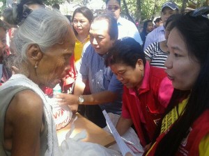 Secretary Dinky Soliman hands food packs to older persons in Sagbayan, Bohol.