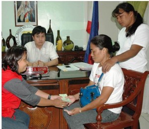 Mrs. Mary Ann Santos, a mother of two children who died in Concepcion, Tarlac receives financial assistance from Ms. Maricel Deloria, division chief of Disaster Risk Reduction and Response Operations Office (DRRROO). The awarding of financial aid was held at the Office of Municipal Mayor Andres D. Lacson Mrs. Mary Ann Santos, a mother of two children who died in Concepcion, Tarlac receives financial assistance from Ms. Maricel Deloria, division chief of Disaster Risk Reduction and Response Operations Office (DRRROO). The awarding of financial aid was held at the Office of Municipal Mayor Andres D. Lacson