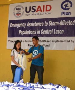 Annie Abitan, Pantawid Pamilya beneficiary from Barangay New Cabalan, Olongapo City, receives her relief pack and jerry can from Social Welfare Assistant Tracy Lloyd Maaghop of Bataan-Zambales Provincial Cluster Operations Office of Pantawid Pamilyang Pilipino Program. 