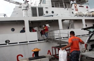 Cebu Coast Guard and DSWD Personnel load relief goods on the coast guard ship.