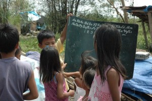 children in Brgy. Mabilog look at the items they have salvaged from their destroyed house.
