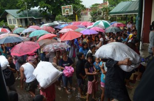 Residents of Barangay Antipolo in San Antonio, Zambales lining up as volunteers carry loads of relief goods for their barangay. The spirit of bayanihan is alive even to people who also need assistance.