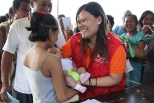 Merj Anunciado, social worker, assists a mother during relief goods distribution in Tubigon, Bohol.
