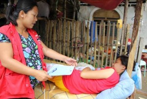 Chona Calamba, Pantawid Pamilya municipal link talks to an evacuee..