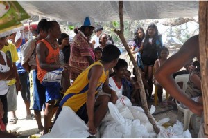 Residents of Brgy. Malawig gather around relief goods and await their names to be called to receive a family foodpack. Relief reached the community a day after the typhoon