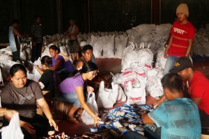 Volunteers at the Tacloban Hub prepare the food packs for distribution to typhoon survivors in E. Visayas.