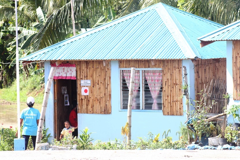A little boy eagerly stands by the door as he waits for his mother to arrive at their new home constructed by DSWD through the Core Shelter Assistance Program.