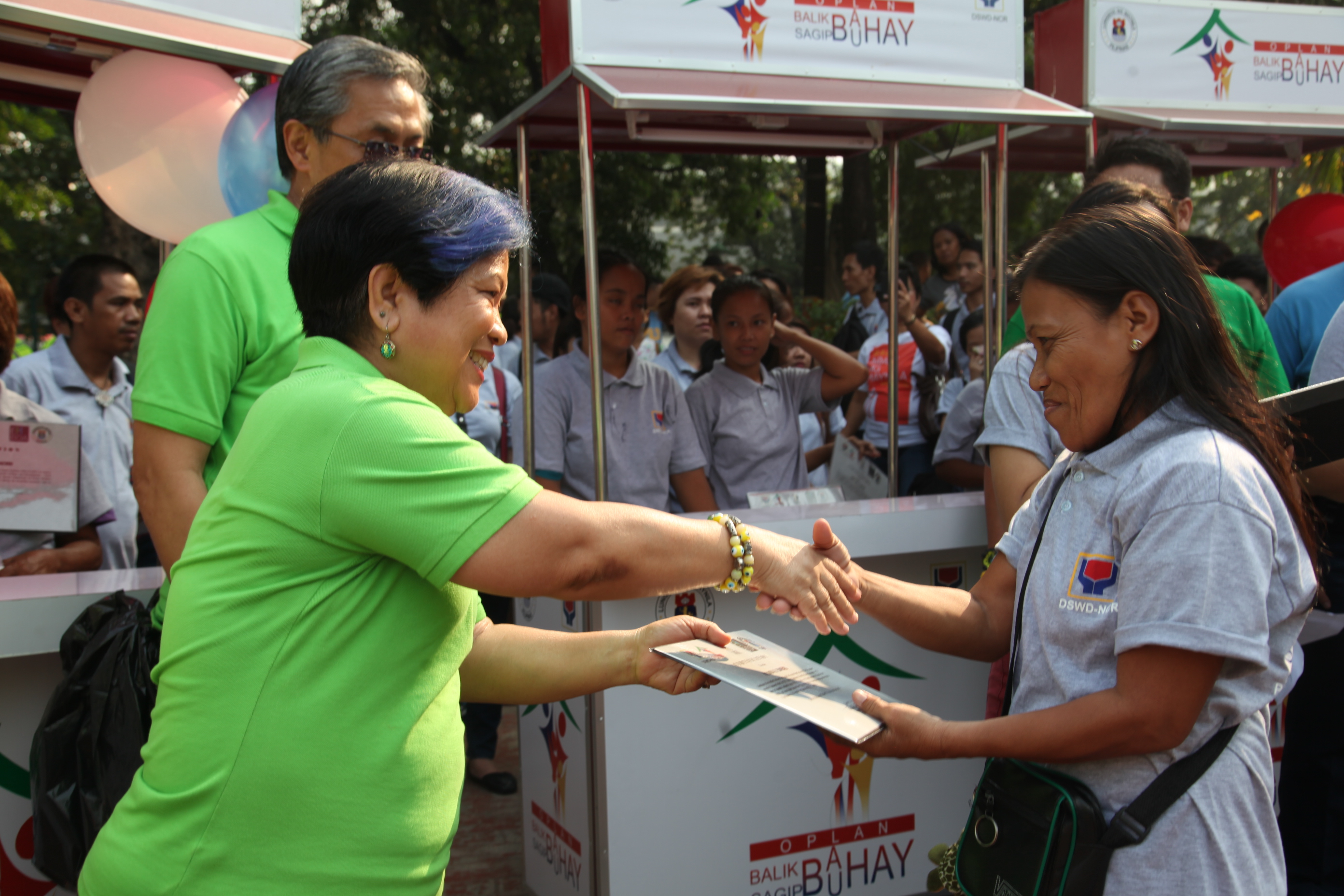 DSWD Sec. Soliman congratulates Melinda Meseres for being one of the recipients of Kabuhuayn Folded Carts during the ceremonial turnover at the Plaza Salamanca.