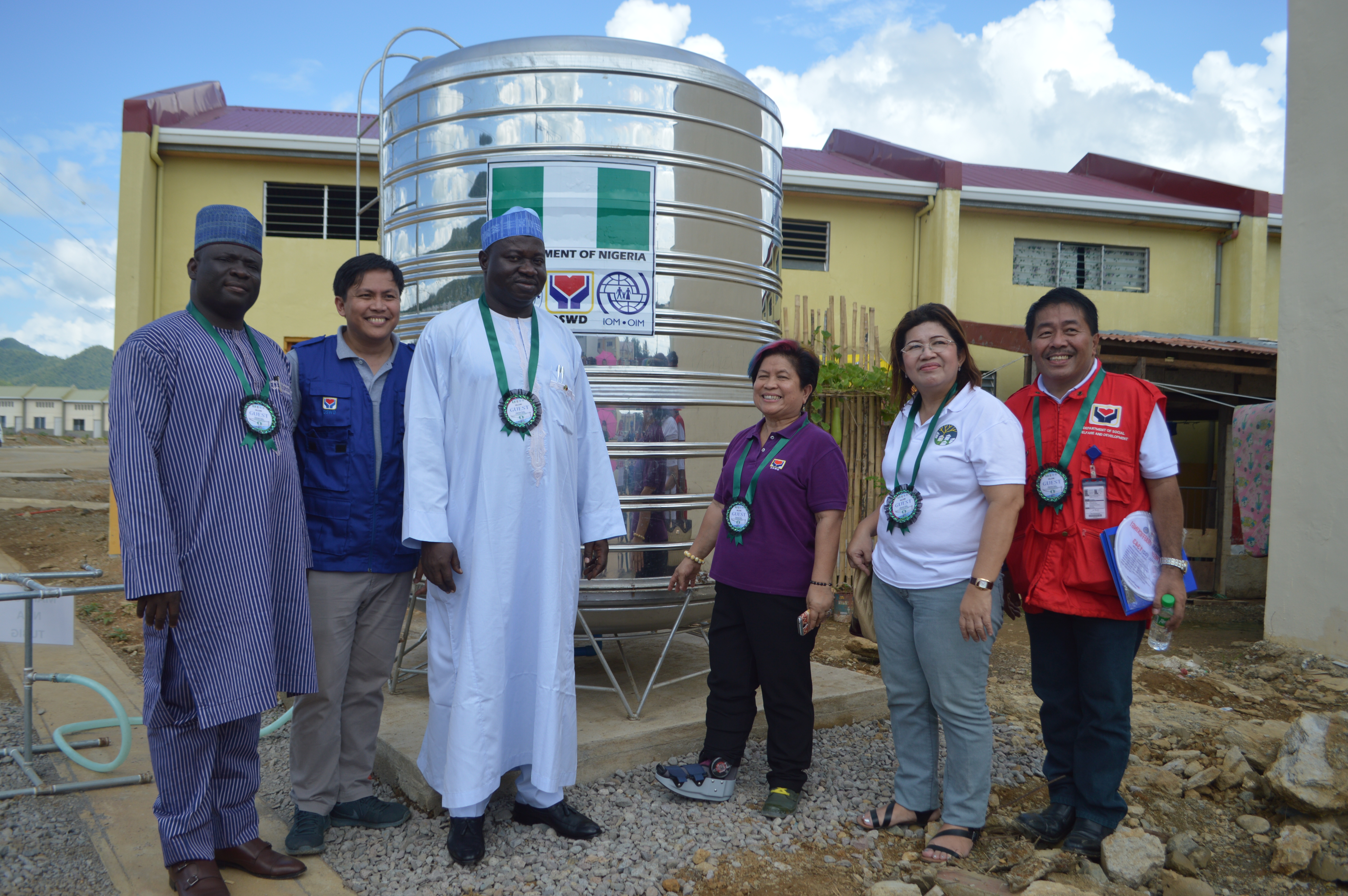 A huge water tank serves as backdrop for a souvenir photo of DSWD Sec. Corazon Juliano-Soliman (3rd from right), Nigerian Ambassador to the Philippines Buba Tekuna and other officials of the DSWD and Nigerian Embassy. The water tank is part of the Water Support System constructed through the donation of the People of Nigeria for Yolanda survivors now residing in Ridgeview Park in Tacloban.