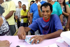 A Surigao quake victim beams as he receives the Emergency Shelter Assistance (ESA) from the Department of Social Welfare and Development. 