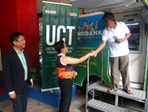 Tatay Reynato Antonio of Barangay Batasan, 74, shakes the hand of Department of Social Welfare and Development (DSWD) Undersecretary Malou B. Turalde after successfully withdrawing his family's cash grant from the Unconditional Cash Transfer (UCT) program amounting to P2,400. Tatay Reynato is just one of the 100 Pantawid Pamilya beneficiaries who withdrew their cash grants at the DSWD Central Office with the assistance of the Landbank of the Philippines. Also in photo is LandBank of the Philippines Assistant Vice President Domingo Conrado Galsim.
