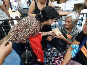 DSWD Secretary Virginia Orogo hands over P25,000 burial aid to a beneficiary.