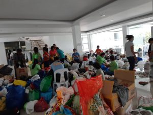 Volunteers try to segregate the donated used clothes for landslide survivors at the Naga City Hall in Cebu.