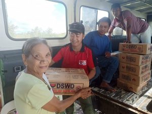Irene Galindon, 73, a resident of Sitio Naruang in Barangay Lanna, town of Enrile, Cagayan receives a family food pack from a member of the Municipal Action Team of the DSWD Field Office in Region II.