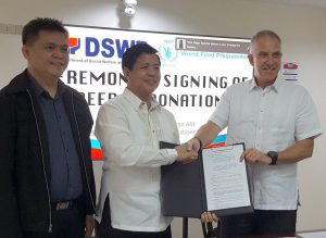 Department of Social Welfare and Development (DSWD) Secretary Rolando Joselito Bautista (middle) formally accepts the signed Deed of Donation for the Mechanized Production System of the Visayas Disaster Response Center (VDRC) from United Nations World Food Programme (UN WFP) Country Director in the Philippines, Mr. Stephen Gluning (right). Also present in the ceremonial signing is DSWD Assistant Secretary for General Administration and Support Services Group Rodolfo Santos (left).