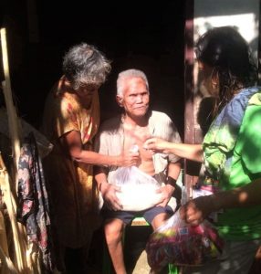 Zenitha Ocampo, a Pantawid Pamilyang Pilipino Program beneficiary from Barangay Talisay, Santa Fe, Cebu, hands over the food packs that she and her fellow beneficiaries prepared for the members of the vulnerable sectors in their village.