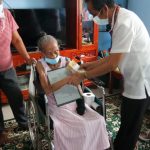 DSWD Field Office I staff hands the PhP100,00 cash gift to Lola Aurea from Alaminos, Pangasinan