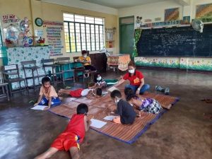 A social worker of the Department of Social Welfare and Development (DSWD) facilitates the psychosocial processing of children evacuees in Guinobatan East Central School, Albay.