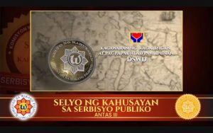 Ang larawang ito ay ang Selyo ng Kahusayan, Antas III na iginawad sa Kagawaran ng Kagalingan at Pagpapaunlad Panlipunan o Department of Social Welfare and Development (DSWD) bilang pagkilala sa paggamit nito ng wikang Filipino sa pagganap nito sa kanyang mandato sa pagbibigay serbisyo publiko.