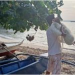Juan, showing off his fishing net and the newly refurbished paddle boats he acquired from Livelihood Settlement Grant