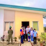 Department of Social Welfare and Development (DSWD) Undersecretary Rene Glen Paje (in red vest) together with a family-beneficiary during the turnover of housing units to KAPATIRAN members in Aklan. The housing project is under the efforts of the PAyapa at MAsaganang PamayaNAn and the Socio-Economic Reintegration Cluster (SERC).