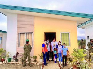 Department of Social Welfare and Development (DSWD) Undersecretary Rene Glen Paje (in red vest) together with a family-beneficiary during the turnover of housing units to KAPATIRAN members in Aklan. The housing project is under the efforts of the PAyapa at MAsaganang PamayaNAn and the Socio-Economic Reintegration Cluster (SERC).