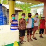 Community volunteers give a thumbs-up during the turnover of handwashing facilities.