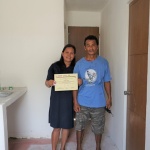 The Teves couple shows their Certificate of Completion, Acceptance, and Occupancy for their new house built through the Core Shelter Assistance Program of the Department of Social Welfare and Development.
