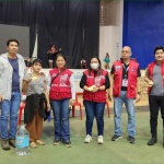 A displaced resident affected by the effects of the Shear Line and flood in Gingoog, Misamis Oriental receives financial assistance and relief items from officials of the Department of Social Welfare and Development (DSWD) Central Office and DSWD Field Office X.