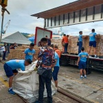Volunteers from the Philippine National Police unload boxes of family food packs delivered by the winged-van of the United Nations-World Food Programme (UN-WFP).