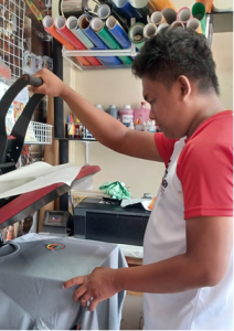 Program beneficiary Jonathan Nares prints on a T-shirt to try out the new equipment that he was able to purchase through the livelihood assistance provided by the Department of Social Welfare and Development’s Sustainable Livelihood Program.